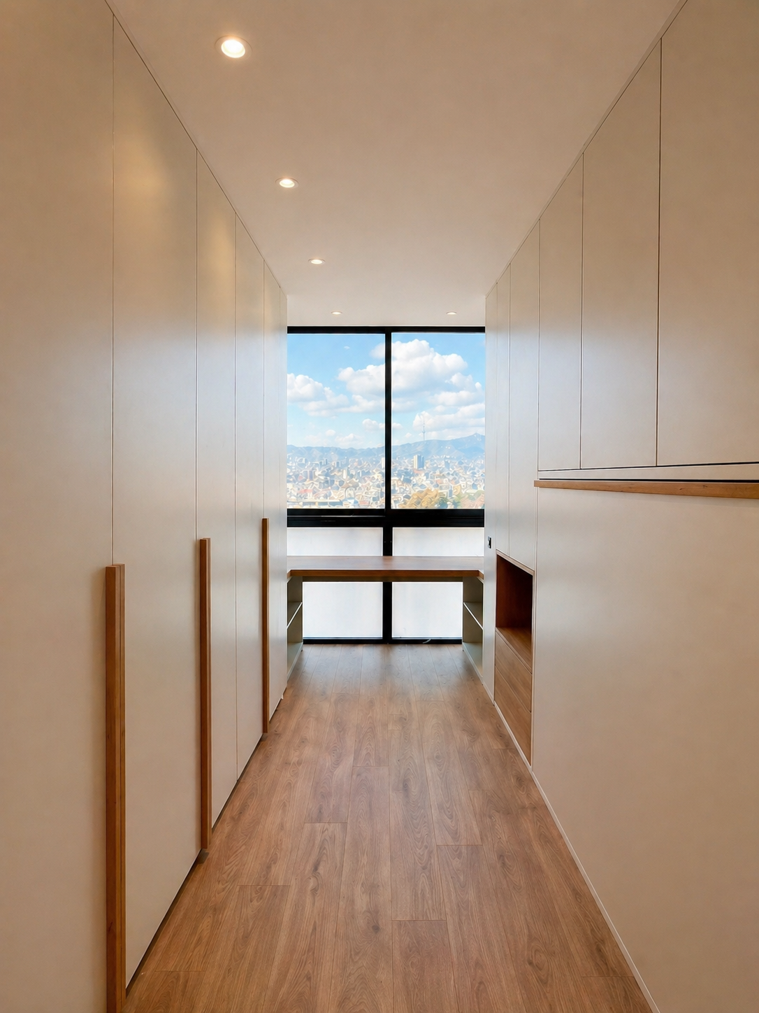 Vestidor walk-in beige con tocador de madera y vistas panorámicas a Barcelona